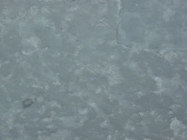 Asphalt texture, blue-grey in color, with blotchy light areas and small amounts of irregular cracking.